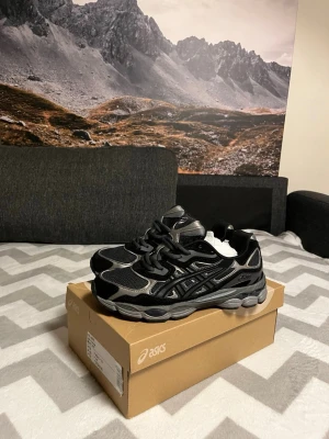 ASICS GEL-NYC svarta sneakers pris kan diskuteras  - ASICS GEL-NYC sneakers i svart och silver med mesh och syntetpaneler. Snygg chunky sula och klassisk snörning. Perfekt för dig som gillar sportig stil och vill ha bekväma skor med cool design. Storlek EU 42.5, US 9. PRISET KAN DISKUTERAS 