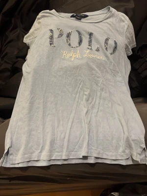 Polo T-shirt -  Säljer en jättefin blå polo t-shirt. Den är i använt skick och lite urtvättad men annars superfin i storlek barn L så ca tolv till 14 år. Säljer på grund av att den inte kommer till användning och att jag tycker att den inte sitter så fint på mig. Köpte i somras och säljer den för 250 kommer tyvärr inte gå under det❤️
