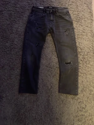 Svarta jeans med slitningar från Replay - Hej. Säljer dessa feta replay jeansen pågrund av att dom är för stora. Jeansen är i modelen ROCCO. Jeansen är uppsydda ifrån 34L till 30L ungefär annars har jeansen inga större defekter. Hör av er om ni har frågor mvh Wallstencloset