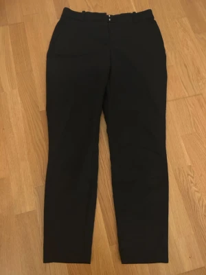 Svarta kostymbyxor  - Snygga svarta kostymbyxor från H&M i storlek 40. Klassisk rak passform med midwaist och bälteshällor. Perfekta för en clean och stilren look. Materialet är mjukt och känns bekvämt mot huden. Byxorna har fickor fram och diskreta bakfickor.💞