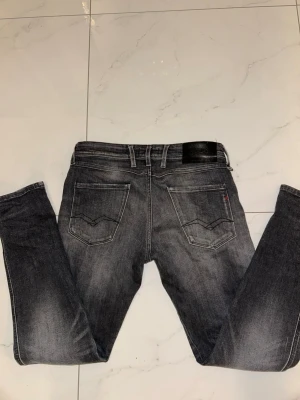 Gråa Replay Anbass jeans - Säker ett par mörkgrå Replay Anbass med snygg tvätt och några sköna slitningar på låren! Fint skick, 8.5/10, inga defekter. Köpta för 2100kr på Johnells. Storlek 29/30 men skulle säga att de sitter större, nästan 30/32. Kan fixa mått! Passar dig runt 180 perfekt ⭐️ 