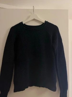 Mörkblå stickad tröja - Säljer denna tjockt virkade mörkblå tröjan. I mycket fint skick, storlek 36.