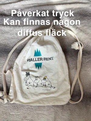 Vit tygpåse med Muminmotiv - Säljer en vit tygpåse med snörning och tryck av Muminfamiljen samt texten 'Vi håller rent'. Perfekt för dig som gillar Mumin och vill ha en enkel och lätt tygpåse till vardagen.🌸Påverkat tryck. Kan finnas någon diffus fläck