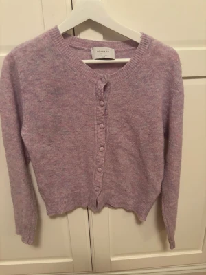 Ljuslila kofta  - Superfin ljuslila kofta köpt på jackie ,. Mjuk stickad känsla med rund hals och knappar framtill. Perfekt att slänga över en t-shirt eller linne. Långärmad och ribbad vid muddar och hals. Lite defekter (kom privat om frågor) 