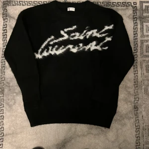 Svart YSL stickad tröja - Svart stickad tröja från Saint Laurent. Boxig passform. Storlek M men sitter mer som en XL/L. Pris kan diskuteras. 