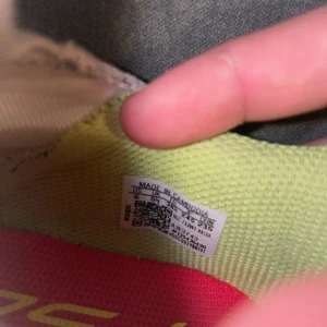 Adidas F50 fotbollsskor i vitt och rött - Säljer ett par Adidas F50 fotbollsskor i vitt med röda och gula detaljer samt svarta ränder. Skorna har en strömlinjeformad design utan snörning och en röd sula med gula dobbar. Ovandelen är i syntetmaterial och insidan är fodrad i gult tyg.