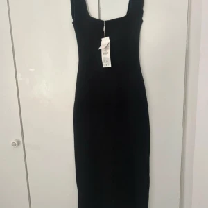 Svart långklänning med breda axelband - Snygg svart långklänning från Zara med breda axelband och fyrkantig ringning. Klänningen har en stilren och figurnära passform. Aldrig använd 