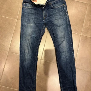 Blå jeans från Acne Studios Blå Konst - Snygga blå jeans från Acne Studios Blå Konst med klassisk femficksdesign och raka ben. Jeansen har en mörkblå tvätt med lätt slitningar och kontrastsömmar. Passar dig som gillar stilrena och tidlösa jeans med svensk design. 32/30