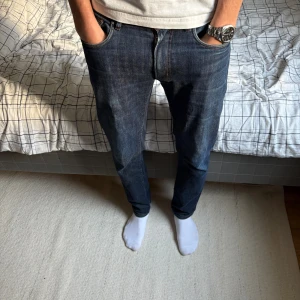 Mörkblå jeans från Oscar Jacobson - Snygga mörkblå jeans från Oscar Jacobson med klassisk femficksdesign och kontrastsömmar. Modellen har rak passform och normal midja, tillverkade i slitstarkt bomullsmaterial. Perfekt för dig som gillar stilrena och tidlösa jeans. Om frågor eller funderingar är det bara att höra av dig!😁