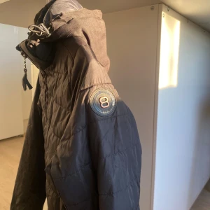 Svart quiltad skidjacka från 8848 Altitude - Säljer en svart quiltad skidjacka från 8848 Altitude med dragkedja framtill, hög krage och justerbara ärmslut med kardborre. Jackan har två fickor med dragkedja och en snygg patch på ärmen. Perfekt för kyliga dagar och stilren look. Använd men i fint skick. Storleken är 170 men kan även användas som en XS.