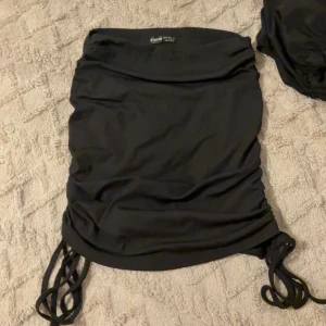 Svart ribbad kortkjol  - Svart kortkjol från shein med snygga snörningsdetaljer på sidorna. Storlek xs, har använts men inga defekter eller fläckar osv. För fler bilder hör av er privat!