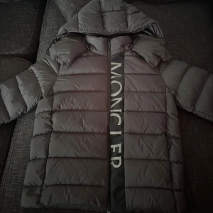 Moncler pufferjacka - Helt nyköpt jacka från Moncler med även plast skydd kvar på dragkedjan och tags! Jackan passade inte mig så bra det är därför jag säljer den. Jackan har huva, långa ärmar och två sidofickor med dragkedja. Den är quiltad och har en oversized look, perfekt för kalla dagar. Materialet är syntet och dun, vilket gör den både lätt och varm. PRIS KAN DISKUTERAS❗️