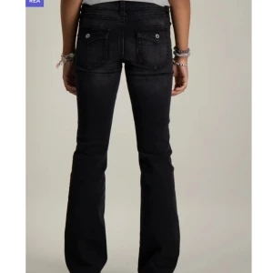 Svarta jeans  - SVART CHUNKY LOW FLARE JEANS i storlek 170 från Gina Tricot Young. Midjan är låg och gylfen består av knapp och dragkedja. Midjan är justerbar på insidan, Bakfickorna har lock och knapp, skriv om ni har frågor🥰