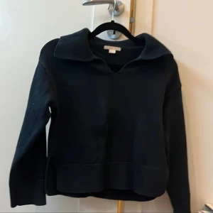 Mörkblå stickad tröja från Gina Tricot - Mysig mörkblå  stickad tröja från Gina Tricot med krage och lång ärm. Tröjan har en avslappnad passform och är perfekt för kyligare dagar. Enkel och stilren design som funkar till många olika outfits.