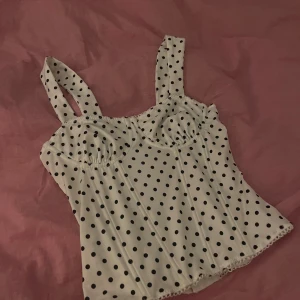 Vit prickig korsett topp - Supersöt vit korsett med svarta prickar, som jag tyvärr ej passar i därför säljs vidare. Det vill säga den är oanvänd eftersom jag inte kunde få på mig den hahah. Kan inte se vilket märke det är btw oxå men skriv ifall ni har andra frågor!💕💕