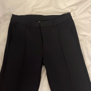 Svarta bootcut kostymbyxor Kappahl 158 - Snygga svarta kostymbyxor från Kappahl i storlek 158. Byxorna har raka/ bootcut-ben. Den har framfickor och lite detaljer fram. Skön i materialet och har en bra passform.💫