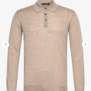 Beige pikétröja i ull från Oscar Jacobson - Snygg beige långärmad pikétröja från Oscar Jacobson i mjuk ull. Klassisk krage och tre knappar framtill ger en stilren look. Perfekt för dig som gillar en clean och tidlös stil.