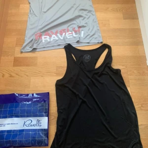 Svart och grå linnetopp från Ravelli - Två sportiga linnetoppar från Ravelli, en i svart och en i ljusgrått med tryckt logga i rött och vitt. Båda har klassisk racerback och är tillverkade i ett lätt och stretchigt material som passar perfekt för träning.