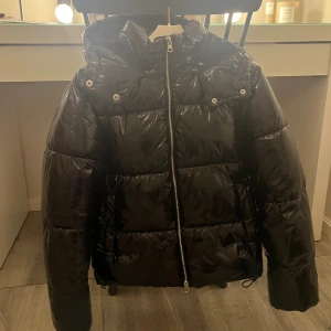 Svart pufferjacka från Nelly XXS - Säljer en svart, trendig, varm, glansig pufferjacka från Nelly i storlek XXS. Jackan har inga tecken på användning och är i superfint skick! skulle även säga att den passa på någon med xs som storlek. Ny priset är 800kr. Bara att höra av dig om du undrar något💞