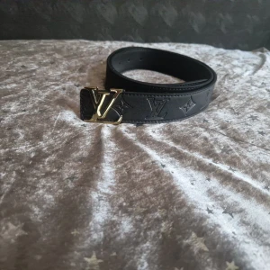 Bälte svart med guld spänne 115 cm - Fint bälte i bra skick 115 cm helsvarta med guld spänne.