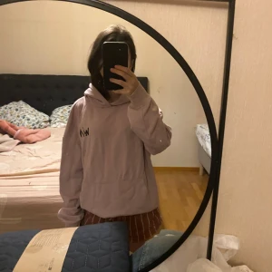 Ljusrosa hoodie - Säljer en ljusrosa hoodie från Stadium med tryck på baksidan. 