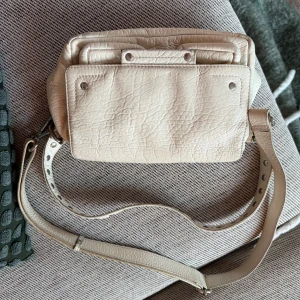 Beige axelväska från Nonoo i skinn - Snygg beige axelväska från Nodoo i mjukt skinn med flera fack och silverfärgade detaljer. Skriv vid funderingar 🫶🏼