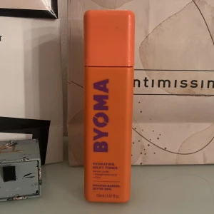 BYOMA Hydrating Milky Toner 150ml - Fuktgivande toner från BYOMA i en snygg orange plastflaska med lila text. Innehåller barrier lipids, polyglutamic acid och cica för att stärka och återfukta huden. Perfekt för dig som vill ha en mjuk och återfuktad känsla.