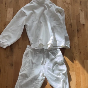 Vit hoodie o mjukis byxor  - Säljer en vit oversized sweatshirt med rund hals och långa ärmar. Tröjan är i mjuk bomull och har en avslappnad passform, perfekt för chill dagar. Enkel och stilren design utan tryck eller detaljer.