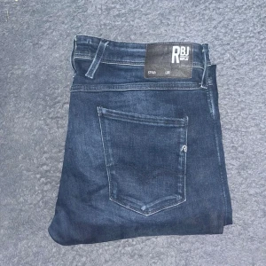 Replay jeans  - Snygga mörkblå jeans från Replay RBJ med skinny passform och klassisk femficksdesign. Jeansen har diskreta slitningar och kontrastsömmar, tillverkade i stretchigt denim för skön komfort. Midja 46cm, längd 109cm. JAG SKICKAR EJ FLER BILDER NÄR JAG BÄR JEANSEN! för storleksguide hänvisar jag till måtten och för bättre inblick i passformen rekommenderar jag att googla på modellnamnet. Jeansen kan vara uppsydda utan att jag noterat det så kolla måtten noggrant :)  29