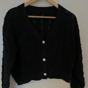 Stickad kofta - Svart stickad croppad kofta med knappar