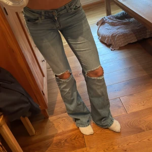 Ljusblå bootcut jeans med slitningar - Säljer ett par jeans från Nelly. Supersnygga! Säljer pga att dem ej kommer till användning. Är lite slitna vid fötterna, värt att ha i åtanke! ❤️