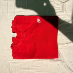 Röd crewneck från Nike XXL - Riktigt snygg röd crewneck från Nike i storlek XXL. Klassisk modell med rund hals, långa ärmar och vit Nike-logga broderad på bröstet. Perfekt för dig som gillar streetwear och vill ha en enkel men stilren tröja.