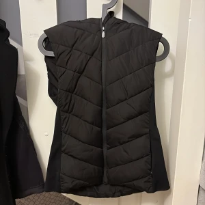 Svart quiltad dunväst från Zara - Svart dunväst från Zara i storlek M med snyggt quiltat mönster och dragkedja. Västen har en tajt midja och har inga defekter eller tecken på användning.