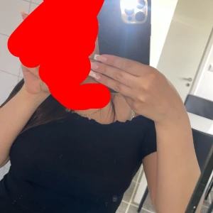 Svart kortärmad topp - En svart, enkel och tight topp med korta ärmar och lätt vågad kant vid halsringningen. Säljer för 60-80kr 