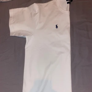 Vit t-shirt från Polo Ralph Lauren - Säljer en klassisk vit t-shirt från Polo Ralph Lauren i big fit passform som är lite stor för mig då jag brukar ha M i vanliga t-shirts så va den lite stor med tanke på att modellen är big fit. Den är äkta och lappen sitter kvar 