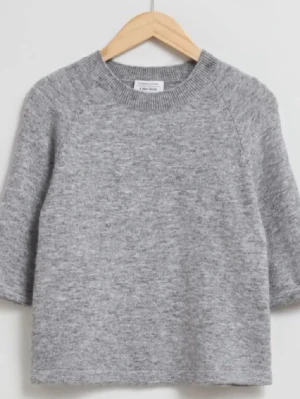 Grå stickad tröja & Other Stories - Mysig grå stickad tröja från & Other Stories med korta ärmar och rund hals. Tröjan är använd men har inga defekter. Den är slutsåld just nu. Hör av er för fler frågor💗💗