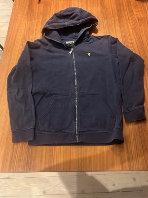 Lyle&scott Zip hoddie - Säljer en blå Lyle&scott zip hoddie i okej skick storlek xs