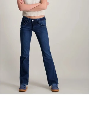 Blå bootcut jeans  - Snygga blå jeans från gina tricot med klassisk bootcut-passform och låg midja. Jeansen har fem fickor, knapp och dragkedja framtill samt raka ben med lätt utsvängning. Perfekta för dig som gillar retrostil och vill ha ett par jeans som sticker ut.