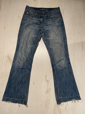 Blå bootcut jeans  - Säljer ett par blå bootcut jeans med rå fransig kant längst ner. Se mått på bild 2&3. Skriv för fler frågor.