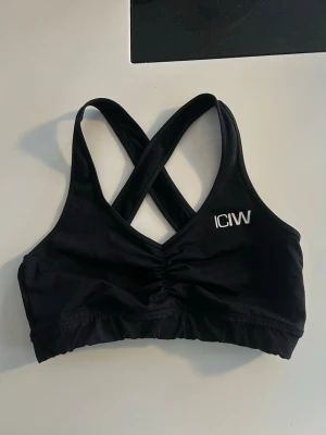 Träningstopp iciw - Supersnygg träningstopp från iciw med korsade band i ryggen.