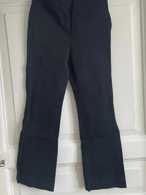 Svarta kostymbyxor från ARKET, strl 38 - Säljer ett par svarta kostymbyxor från ARKET i storlek 38. Byxorna har raka ben och en klassisk passform med lite vidare siluett nedtill. Perfekta till en clean och stilren look. Materialet känns mjukt och följsamt.