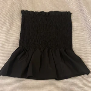 Svart volang smock topp - Säljer denna suuper fina svarta smock volang topp. Använd 2 gånger! Super bra skick utan några defekter eller fläckar💗Tryck gärna på köp nu💗