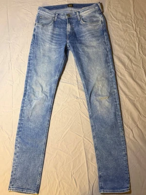 Lee Luke Jeans Ljusblå – Slim Fit – W31 / W32 – Grymt skick - Säljer ett par Lee Luke jeans i ljusblå färg, slim fit, i grymt skick. Väldigt snygg tvätt och färg som funkar perfekt till både vardag och mer uppstyrda outfits.  Luke-modellen är en av Lees mest populära passformer – modern slim fit som sitter snyggt utan att bli för tight. Enkla att matcha med sneakers, boots eller loafers.  • Märke: Lee • Modell: Luke • Färg: Ljusblå • Midja: W31 / W32 • Passform: Slim fit • Skick: Grymt skick                                                         Lee 1