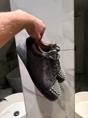 Christian Louboutin - Säljer ett par grå sneakers från Christian Louboutin i nyskick. Fick de i julklapp men var två storlekar för små, gick inte att lämna tillbaka pågrund av borttappat kvitto:( Därför säljer jag de så billigt.