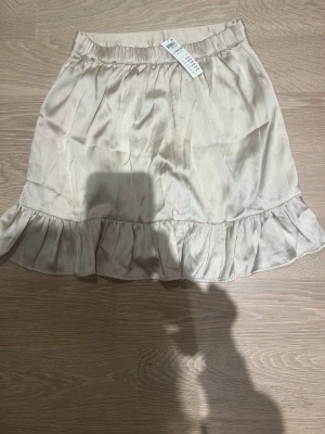 Kjol från lindex - Supersöt guldig satin kortkjol från Zara i glansigt material. Kjolen har resår i midjan och en volang längst ner som ger en extra touch. Perfekt att styla med en enkel topp eller stickad tröja. Passar mig som ofta har storlek xs och sälje pga att den inte används längre💕💕 pris kan diskuteras!