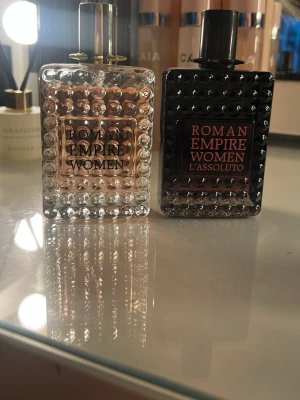 Roman Empire Women duo - Två snygga parfymer: Roman Empire Women 100ml och Roman Empire Women L'Assoluto 100ml. Perfekt för dig som vill sticka ut med stilren design på hyllan. Volym och ingredienser syns ej på bilden. Den svarta är endast testad 2 gånger båda för 50kr