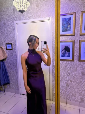 Balklänning  - Säljer en elegant långklänning i djup lila med halterneck och öppen rygg. Superfin i ryggen och framtill elegant o vacker🫶använd en gång 