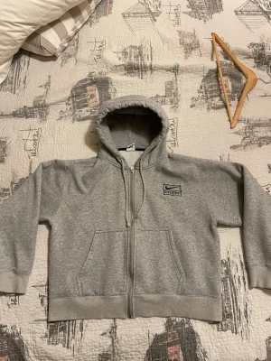 Nike x Stüssy Zip Up Hoodie - Säljer min Nike x Stüssy Zip Up Hoodie i toppkvalitet. Hoodien har en lite cropped passform som ger en modern och snygg siluett utan att kännas för kort. Insidan är fleece‑lined bomull, vilket gör den extremt mjuk, varm och bekväm — perfekt för både vardag och layering.  Materialet är tjockt och premium, och hoodien håller formen riktigt bra. Använd sparsamt och i mycket fint skick.  En perfekt piece för dig som gillar streetwear med hög kvalitet och clean design. Thrifted