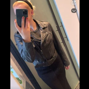 Svart skinnjacka med bälte - Säljer en svart skinnjacka, står att den är i storlek 40 men passar mig som har 38 ( S ) i vanliga fall. Köptes för ungefär 1000 kr, den har aldrig kommit till användning tyvärr. Säljer för 400