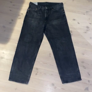 Svarta loose fit jeans från H&M - Svarta jeans från H&M i loose fit-modell. Klassisk femficksdesign och raka ben, perfekta för en avslappnad och trendig look. Jeansen är tillverkade i ett robust denimtyg och har en snygg mörk tvätt.